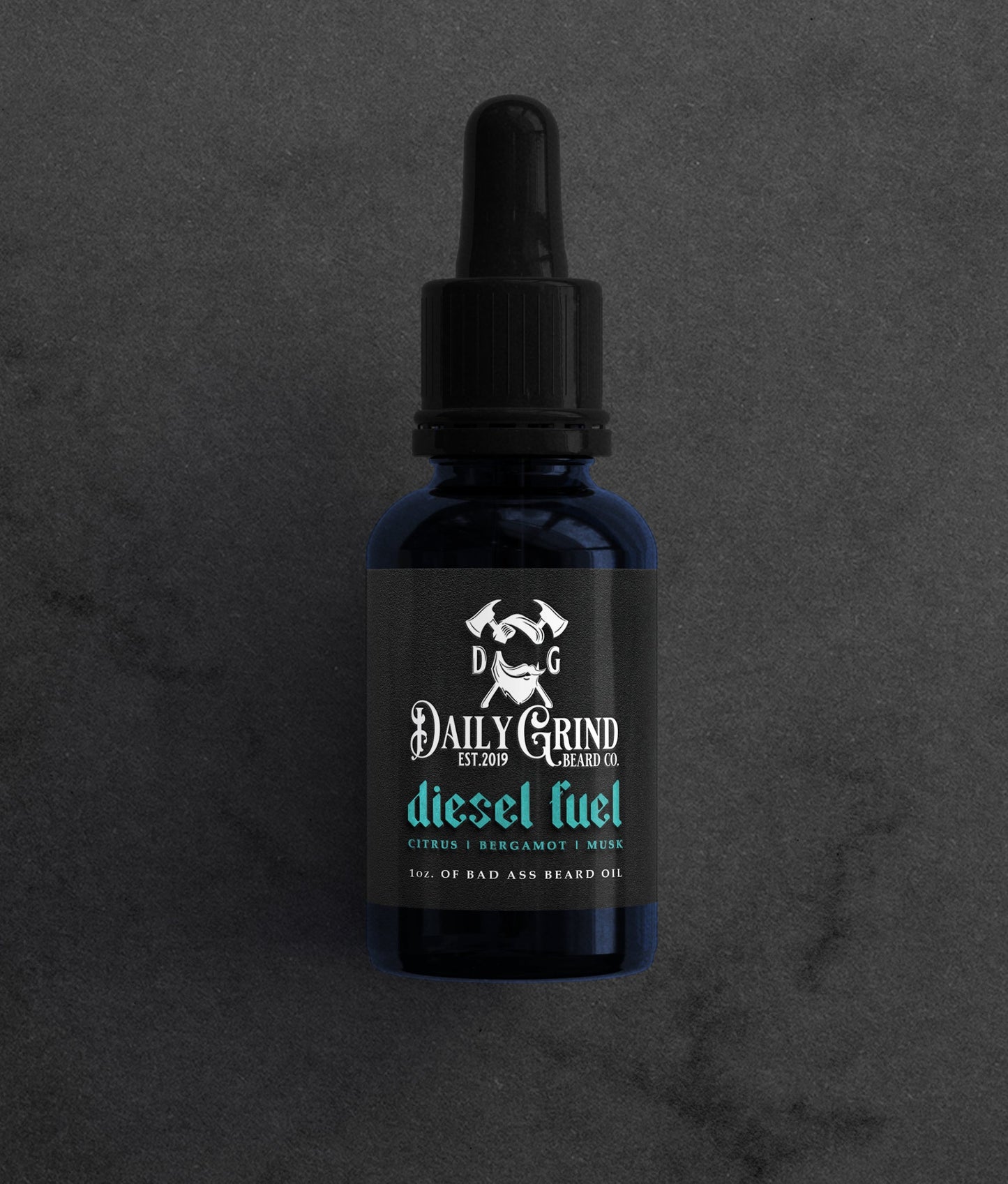 Diesel Fuel citrus bergamot musk beard oil for men by Daily Grind in a blue bottle on a dark stone background