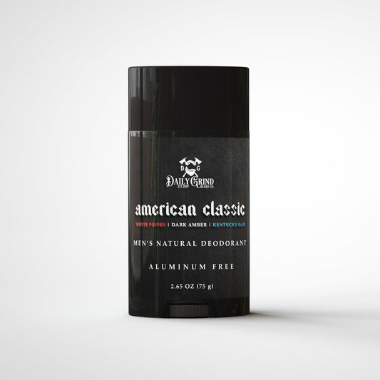 Daily Grind American Classic Deodorant in white pepper, dark amber, and Kentucky oak scent, natural aluminum-free deodorant for men shown in a matte black twist-up stick on a white background