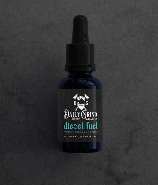 Diesel Fuel citrus bergamot musk beard oil for men by Daily Grind in a blue bottle on a dark stone background